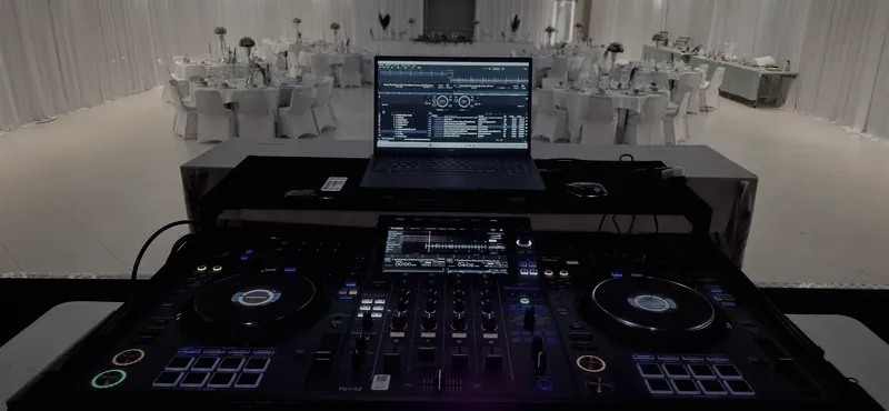 Salle de mariage décorée en blanc, vue depuis les platines du DJ